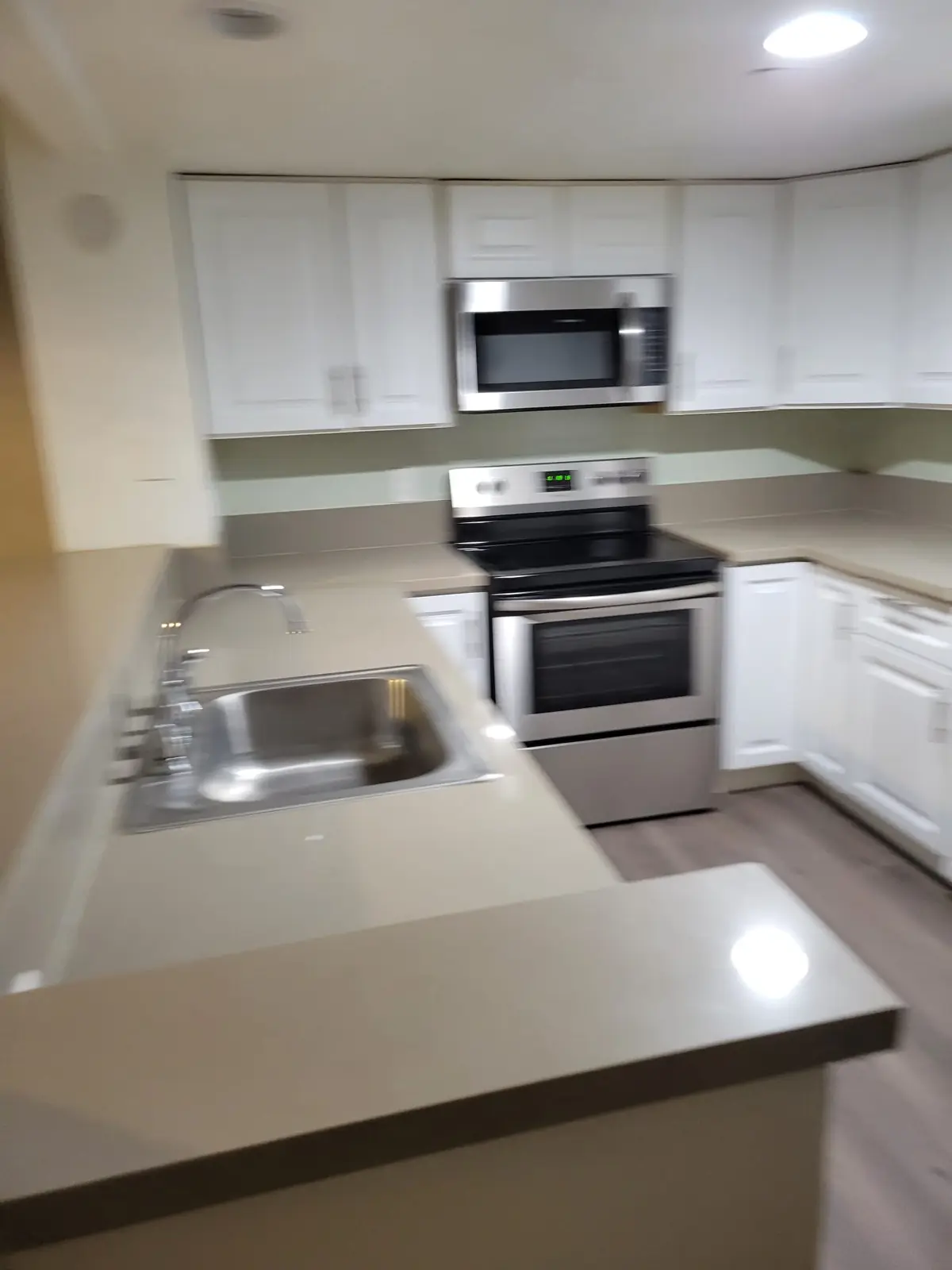 Apartment kitchen with white cabinets and clean counters in Santa Ana