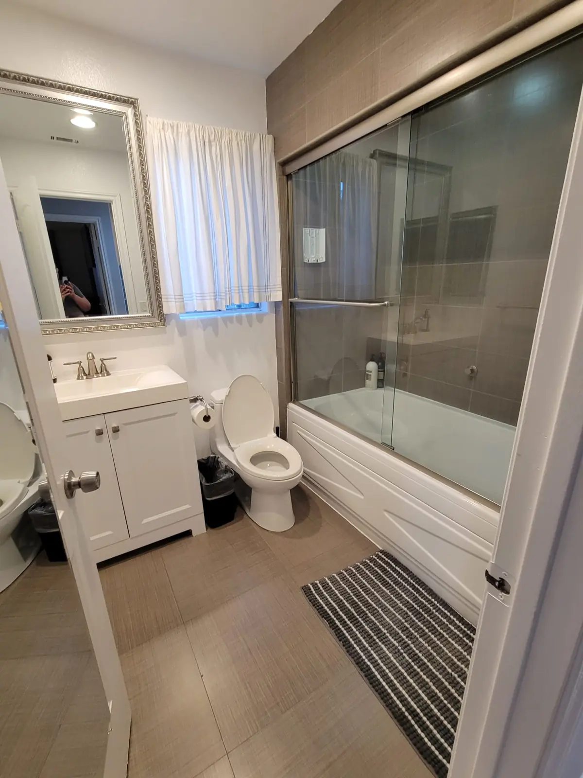 Apartment bathroom with tub and vanity after cleaning