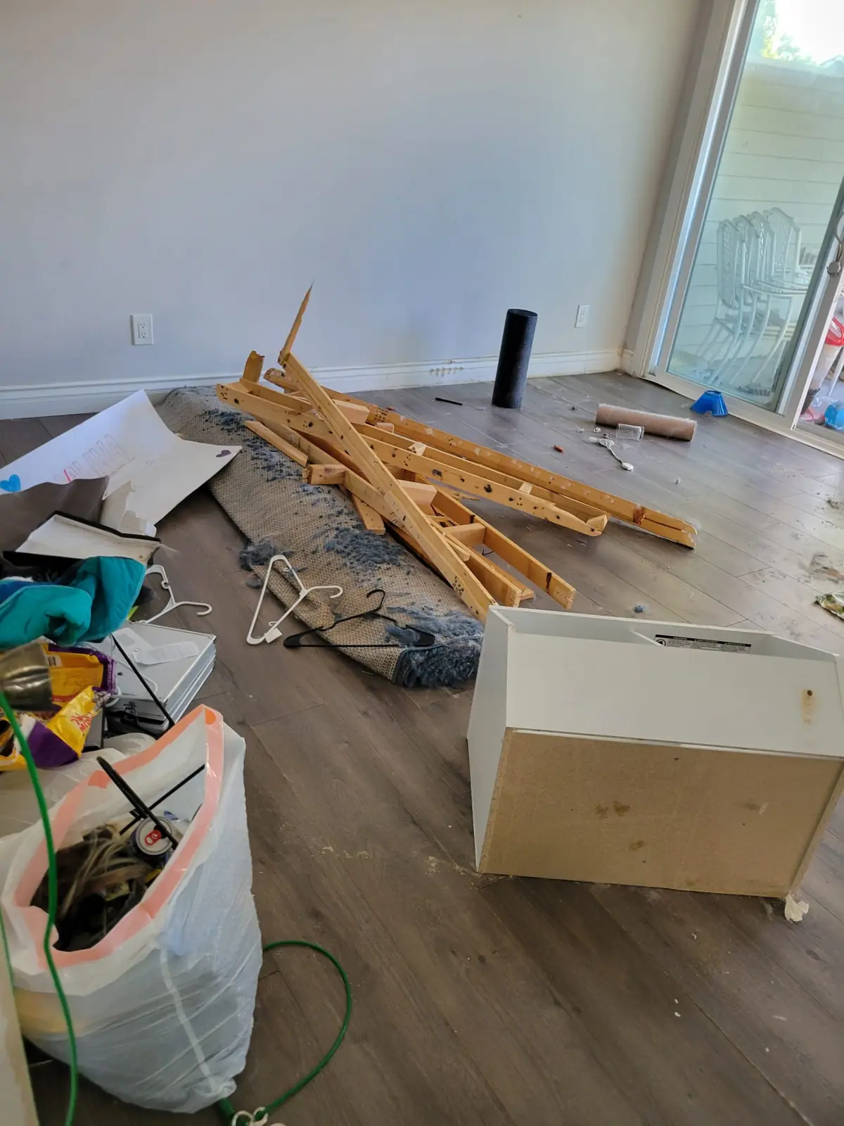 Leftover wood, bags and debris on the floor of a room