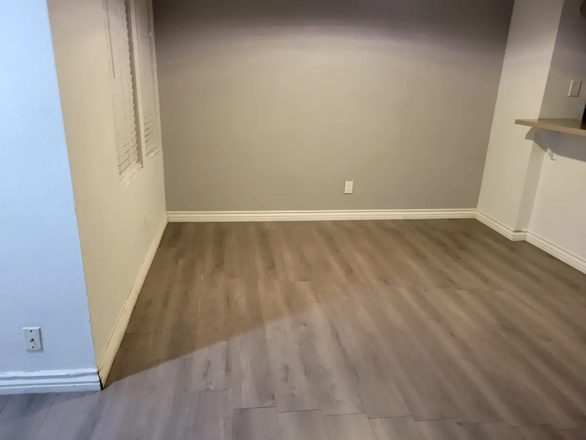 Empty room with clean gray floors and baseboards