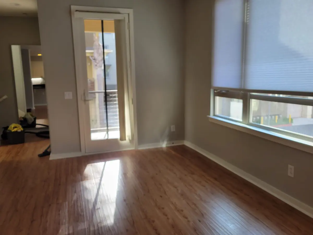 Room with tall windows and a glass door after cleaning