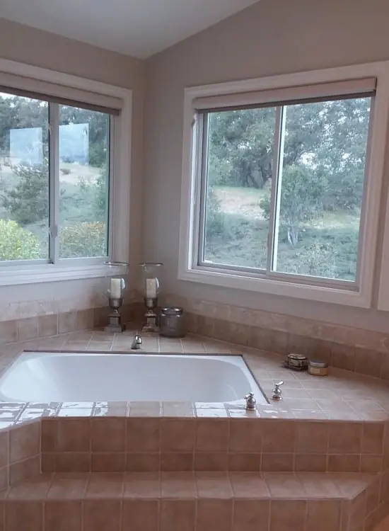 Bathroom with corner windows over a tub in a home cleaned in Santa Ana